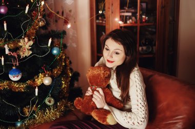 Noel ağacı içinde belgili tanımlık ev yakınındaki oyuncakla mutlu gülümseyen şehvetli kız