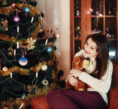 Noel ağacı içinde belgili tanımlık ev yakınındaki oyuncakla mutlu gülümseyen şehvetli kız