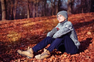 Şık mutlu yakışıklı genç kazak ve fincan çay ya da kahve sonbahar Park ile şapka