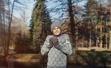 Genç gülümseyen adam dikey, bir fincan çay ya da kahve güneşli 