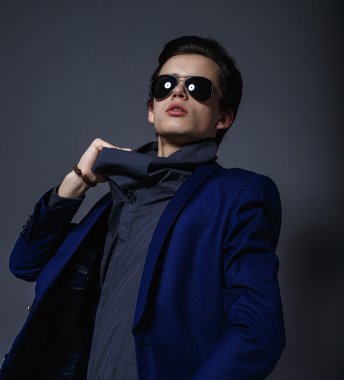 Vogue yakışıklı erkek ceket ve stüdyoda güneş gözlüğü