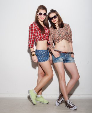 Güzel esmer kız, parlak makyaj, pembe dudaklar, kameraya bakıyor ve gülümsüyor. Rahat kıyafetler ve saç bandı