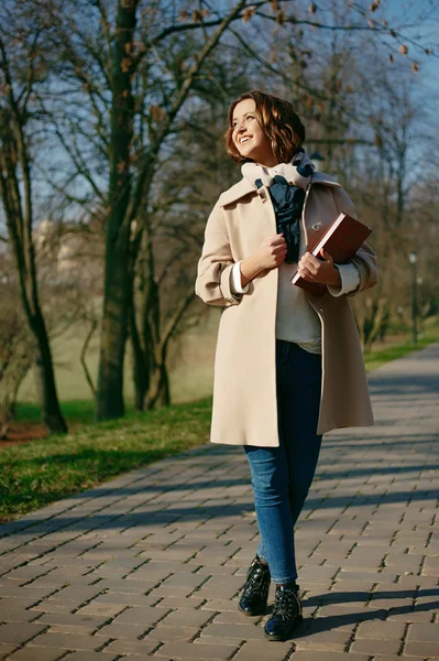 Stijlvolle hipster lachende meisje student met het boek in het park buiten — Stockfoto