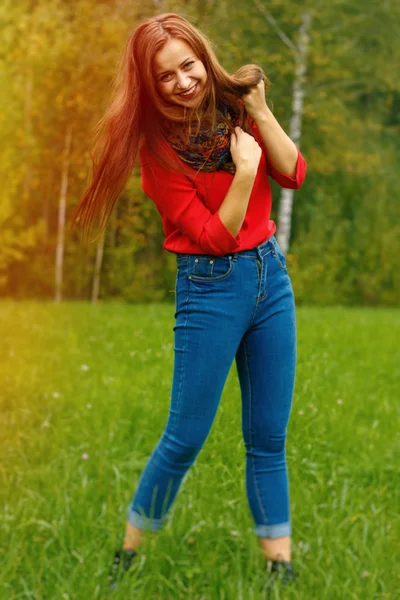 Vogue chica feliz en el suéter rojo y jeans y bufanda al aire libre —  Fotos de Stock