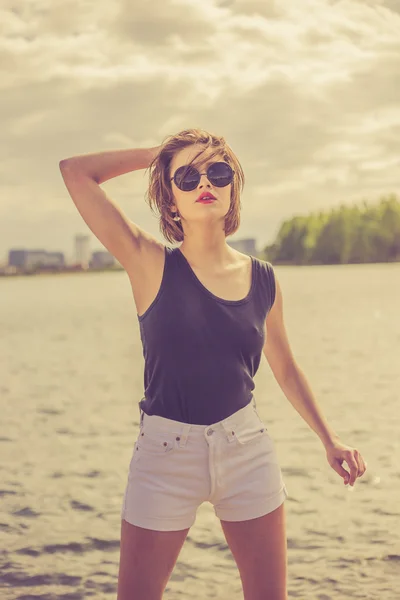 Menina sensual bonita nos óculos de sol perto de retrato de água — Fotografia de Stock