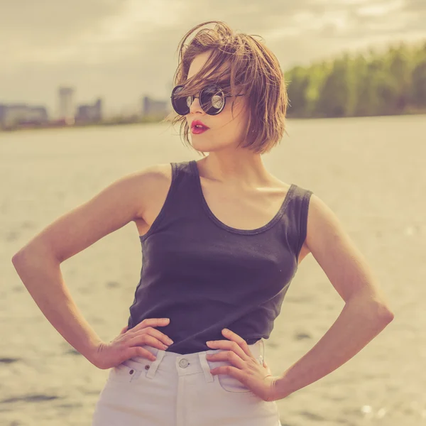 Чувственная девушка в солнцезащитных очках рядом с водным портретом — стоковое фото
