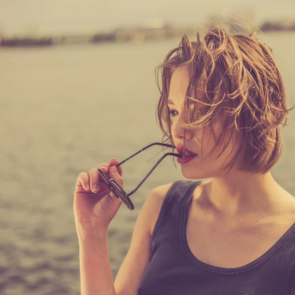 Belle fille sensuelle dans les lunettes de soleil près du portrait de l'eau — Photo