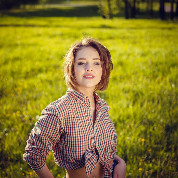 Stylish girl in the plaid shirt outdoor — Stock Photo, Image