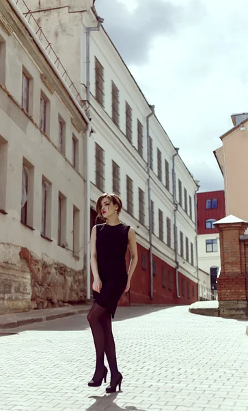Модель Vogue в чорній сукні на відкритому повітрі біля будівлі — стокове фото