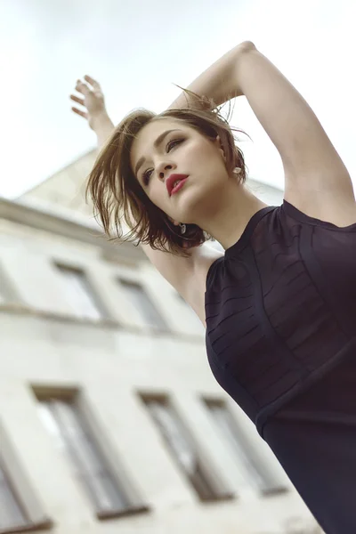 Modelo Vogue en el vestido negro al aire libre cerca del edificio —  Fotos de Stock