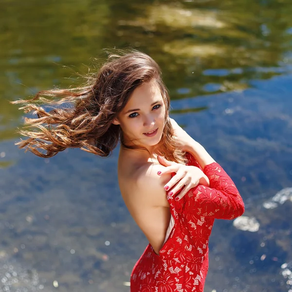 Vogue hermosa chica sensual en el vestido rojo cerca de la cascada — Foto de Stock