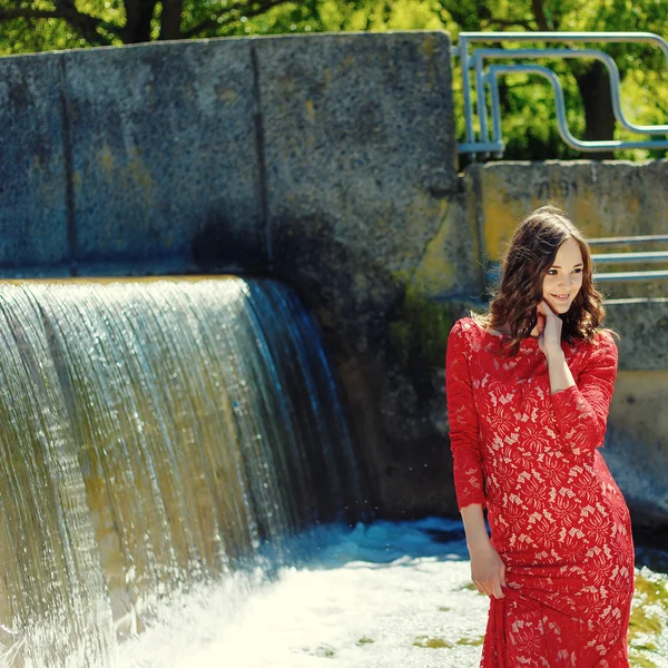 Vogue bela menina sensual no vestido vermelho perto de cachoeira — Fotografia de Stock