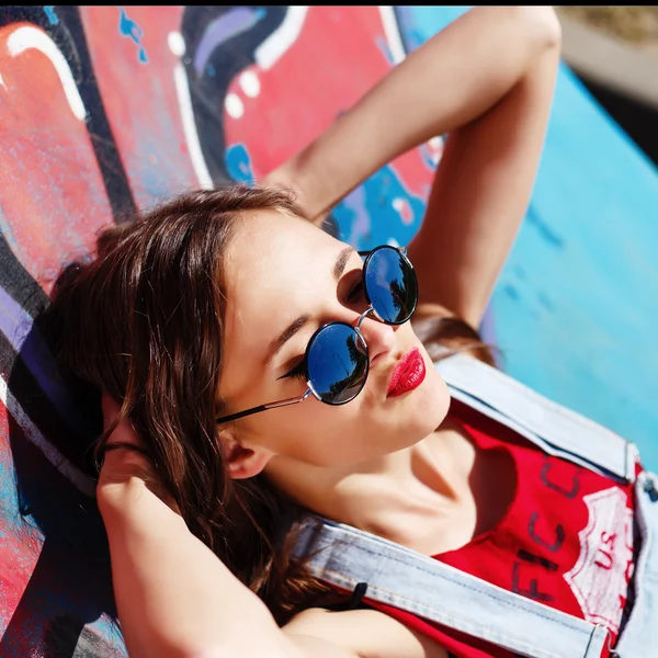 Hipster chica en los pantalones vaqueros y gafas de sol al aire libre retrato —  Fotos de Stock
