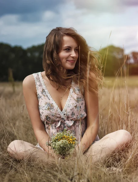 Чуттєва романтична дівчина з квітами в полі — стокове фото
