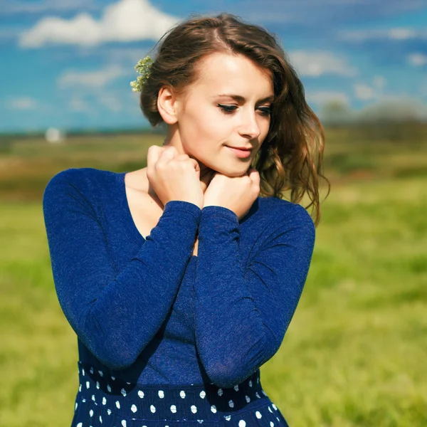 Menina hipster elegante no vestido azul com as flores no campo — Fotografia de Stock