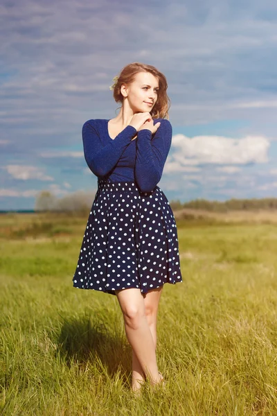 Menina hipster elegante no vestido azul com as flores no campo — Fotografia de Stock