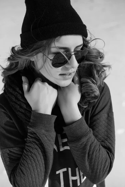 Chica de alta moda en el suéter y gafas de sol al aire libre en el tiro blanco y negro de invierno —  Fotos de Stock