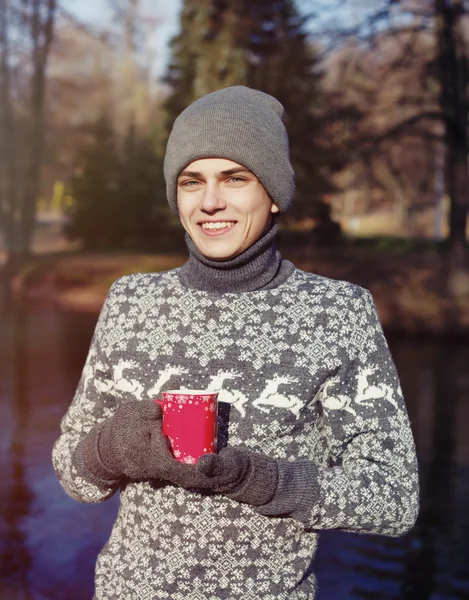 Портрет молодої усміхненої людини з чашкою чаю або кави в сонячному — стокове фото