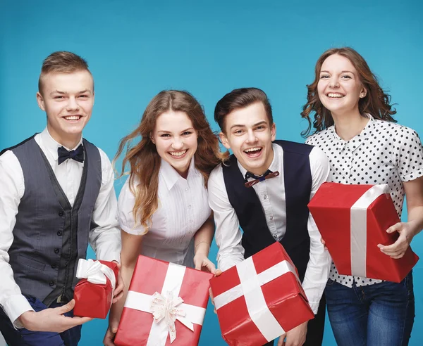 Estudiantes sosteniendo cajas de regalo rojas. Modelo de estudio femenino y masculino posando. Estilo Hipster — Foto de Stock