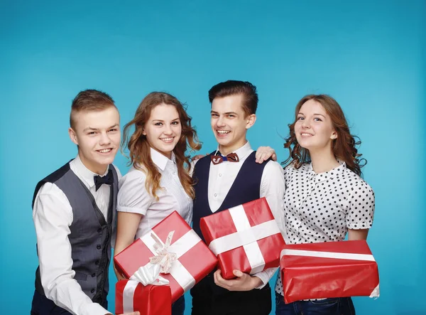 Estudiantes sosteniendo cajas de regalo rojas. Modelo de estudio femenino y masculino posando. Estilo Hipster — Foto de Stock