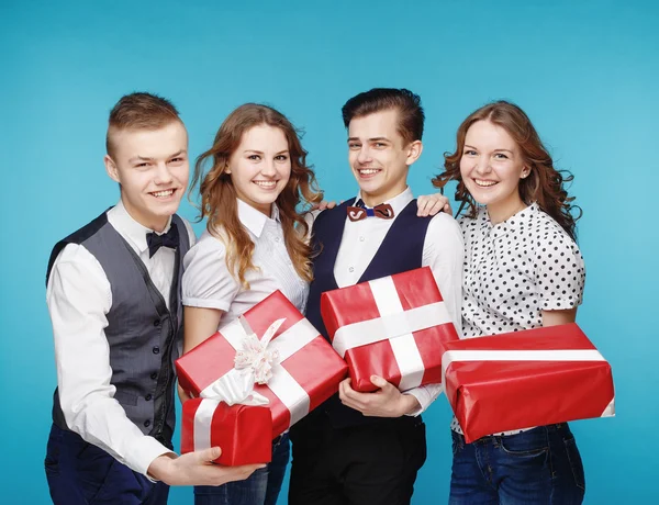Estudiantes sosteniendo cajas de regalo rojas. Modelo de estudio femenino y masculino posando. Estilo Hipster — Foto de Stock