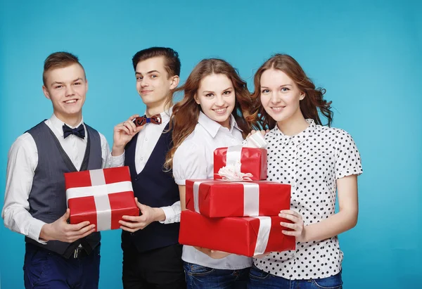 Students holding red gift boxes. Female and male model studio posing. Hipster Style