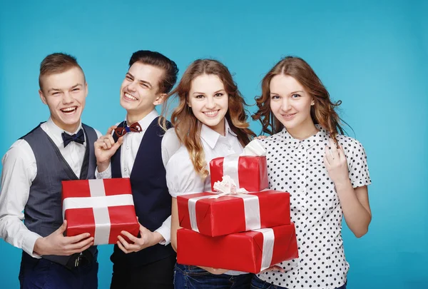 Students holding red gift boxes. Female and male model studio posing. Hipster Style