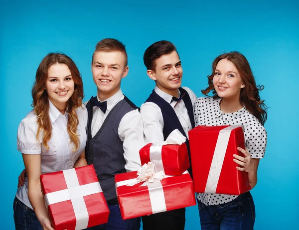 Estudiantes sosteniendo cajas de regalo rojas. Modelo de estudio femenino y masculino posando. Estilo Hipster — Foto de Stock