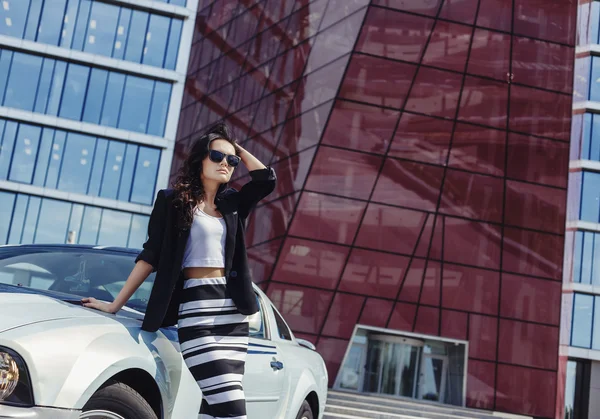 Hermosa mujer de negocios en el fondo de la oficina moderna cerca del coche deportivo —  Fotos de Stock