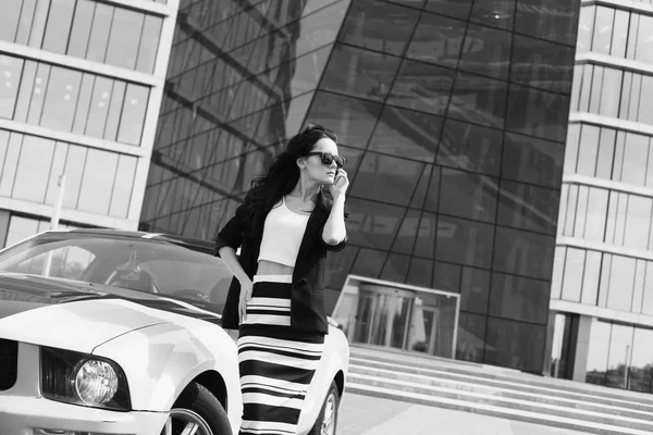 Красива ділова жінка на тлі сучасного офісу біля спортивного автомобіля — стокове фото