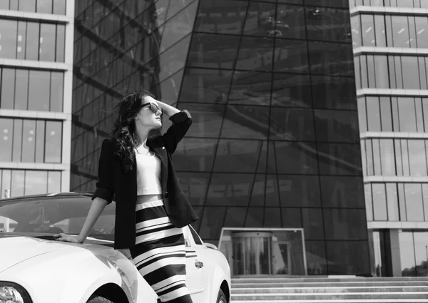 Schöne Geschäftsfrau im Hintergrund des modernen Büros in der Nähe des Sportwagens — Stockfoto