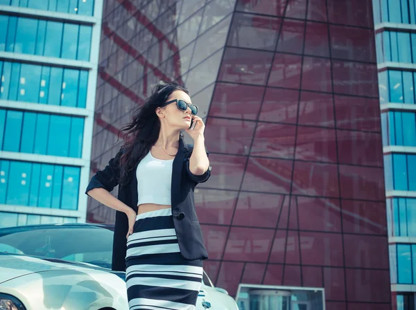 Hermosa mujer de negocios en el fondo de la oficina moderna cerca del coche deportivo —  Fotos de Stock