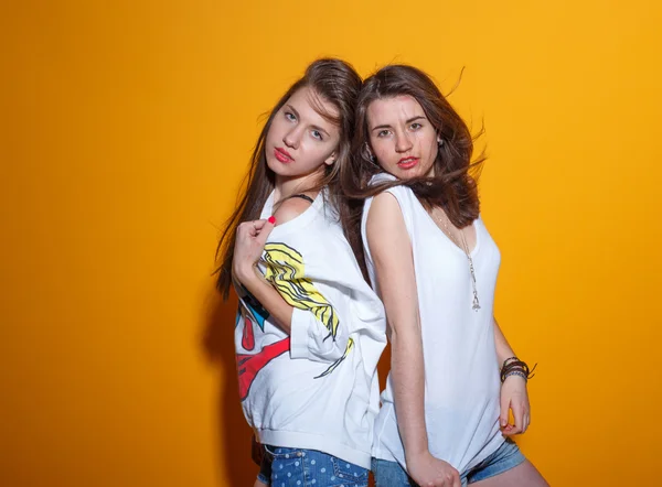 Close up stile di vita di moda ritratto di due giovani ragazze hipster migliori amici, indossando trucco luminoso e vestiti alla moda, facendo facce divertenti e hanno tempo grigio. Contesto urbano . — Foto Stock