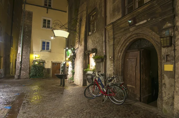 Bicycles on empty medieval street in Innsbruck at night — Stock Photo, Image