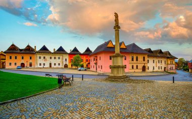 Marian sütunlu ortaçağ Spisska Sobota kasabası ve merkez meydandaki tabakçıların tarihi renkli evleri. Poprad City, Slovakya. Yanan bir gökyüzü. Popüler seyahat hedefi