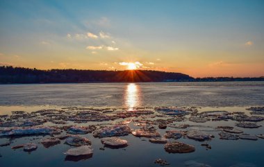 Gün batımında Ukrayna 'nın Cherkasy şehrinde Dinyeper nehrinde buz sürükleniyor..