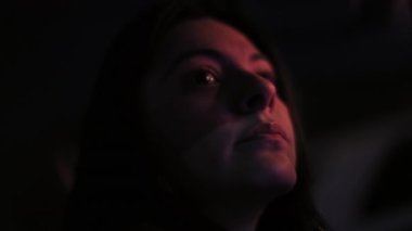 Düşünceli bir ifadeyle gece araba süren Latin bir kadının yakın çekim görüntüsü, gece boyunca direksiyon başında düşünceli bir ruh hali.