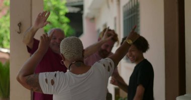 Bir grup farklı arkadaş, hareketli bir açık havada dans ediyor. Topluluğu, eğlenceyi ve birlikteliği kutluyorlar. Sıradan ve neşeli bir atmosferde.