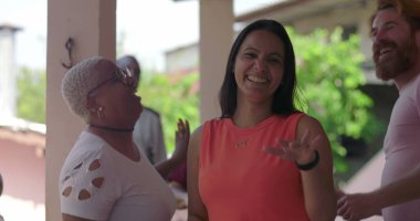 Neşeli çeşitli gruplar bir verandada gülüyor ve dans ediyor, neşeli arkadaşlar coşkulu bir açık hava ortamında kutlama ve bağ kuruyor, mutluluğu ve bağlantıyı yakalıyorlar.