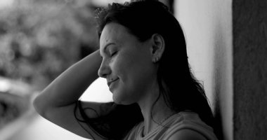 Duvara yaslanmış bir kadın, alnına yaslanmış, pişmanlık ve duygusal ifade, siyah beyaz yakın plan, derin yansıma ve pişmanlık anı