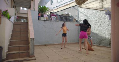 Çocuklar dışarıda birlikte oynuyorlar, zıplıyorlar ve gülüyorlar, kaygısız çocukluk anlarından zevk alıyorlar, enerji, eğlence, aktif çocuklar, aile bağları, güneş altında eğlenceli zamanlar.