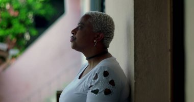 Latin kökenli Afrikalı bir kadın, elini kaldırmış ve el kol hareketi yapıyor, derin duygular gösteriyor, zor zamanlarda eziliyor ve pişmanlık duyuyor, doğal arka plan