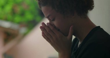 Duygusal sıkıntı içindeki genç bir çocuk, elleri yüzünü kapatıyor, ağlıyor, duvara yaslanıyor, Afrika kökenli, açık hava manzaralı, yakın plan.