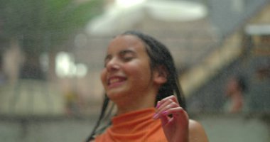 Suyun altında neşeyle oynayan çocuk, dinamik hareketlerle uçan saçlar, kaygısız bir heyecan, gençlik enerjisi ve serinletici yaz eğlencesi.