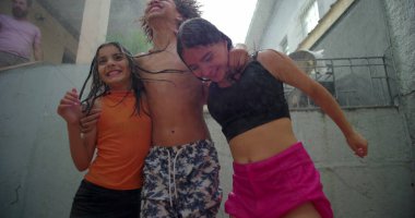 Çocuklar arka bahçedeki toplanma sırasında su altında gülüp kucaklaşıyorlar, neşeli ve kaygısız anları canlı ve oyuncu bir açık hava ortamında paylaşıyorlar