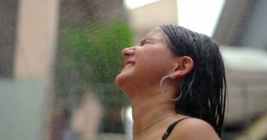 Suyun tadını çıkaran gülümseyen çocuk, başını arkaya eğ, neşe ve kaygısızlıkla yüzleş, sıcak bir yaz gününde hayat dolu ve ferahlatıcı anları yakala.