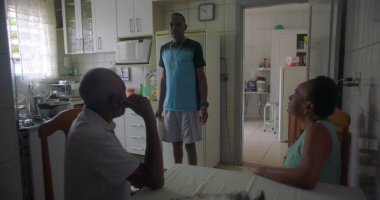 Afrika kökenli bir aile mutfakta toplandı. Yaşlı bir çift masada otururken bir adam yakınlarda, rahat ve samimi bir aile bağı ve günlük yaşam sürüyor.