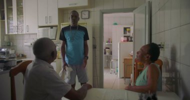 Afrika kökenli bir aile mutfakta toplandı. Yaşlı bir çift masada otururken bir adam yakınlarda, rahat ve samimi bir aile bağı ve günlük yaşam sürüyor.
