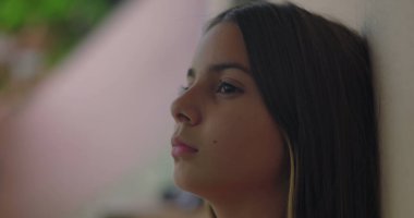 Duvara yaslanmış genç bir kız, sakin ve düşünceli bir ifade sergileyen, her gün barışı, gençliği ve farkındalığı sembolize eden bir profil.