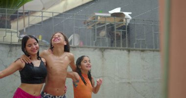 Suyun altında oynayan, kahkaha atan ve bir çember halinde el ele tutuşan, farklı etnik kökenlere sahip gülümseyen çocuklar, kaygısız neşe ve coşkulu yaz eğlenceleri yakalıyorlar.